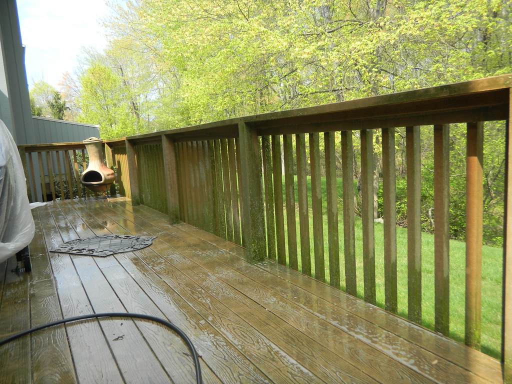 Freshly waterblasted wooden deck with wet boards and railing after cleaning