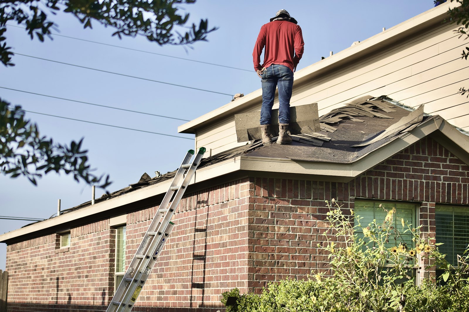 Tradesperson standing on a house roof during exterior roof work